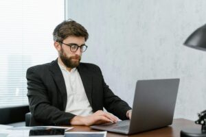 A professional man working on his laptop about personal brand.
