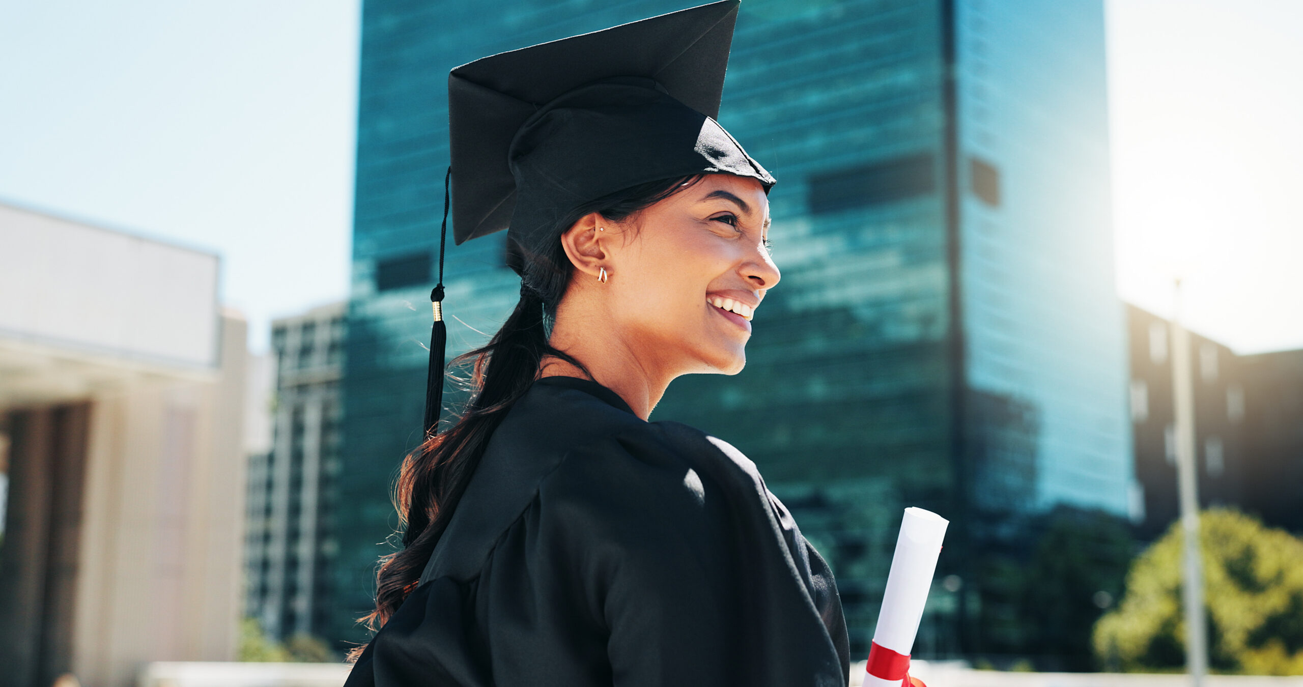 A new graduate holding her diploma.